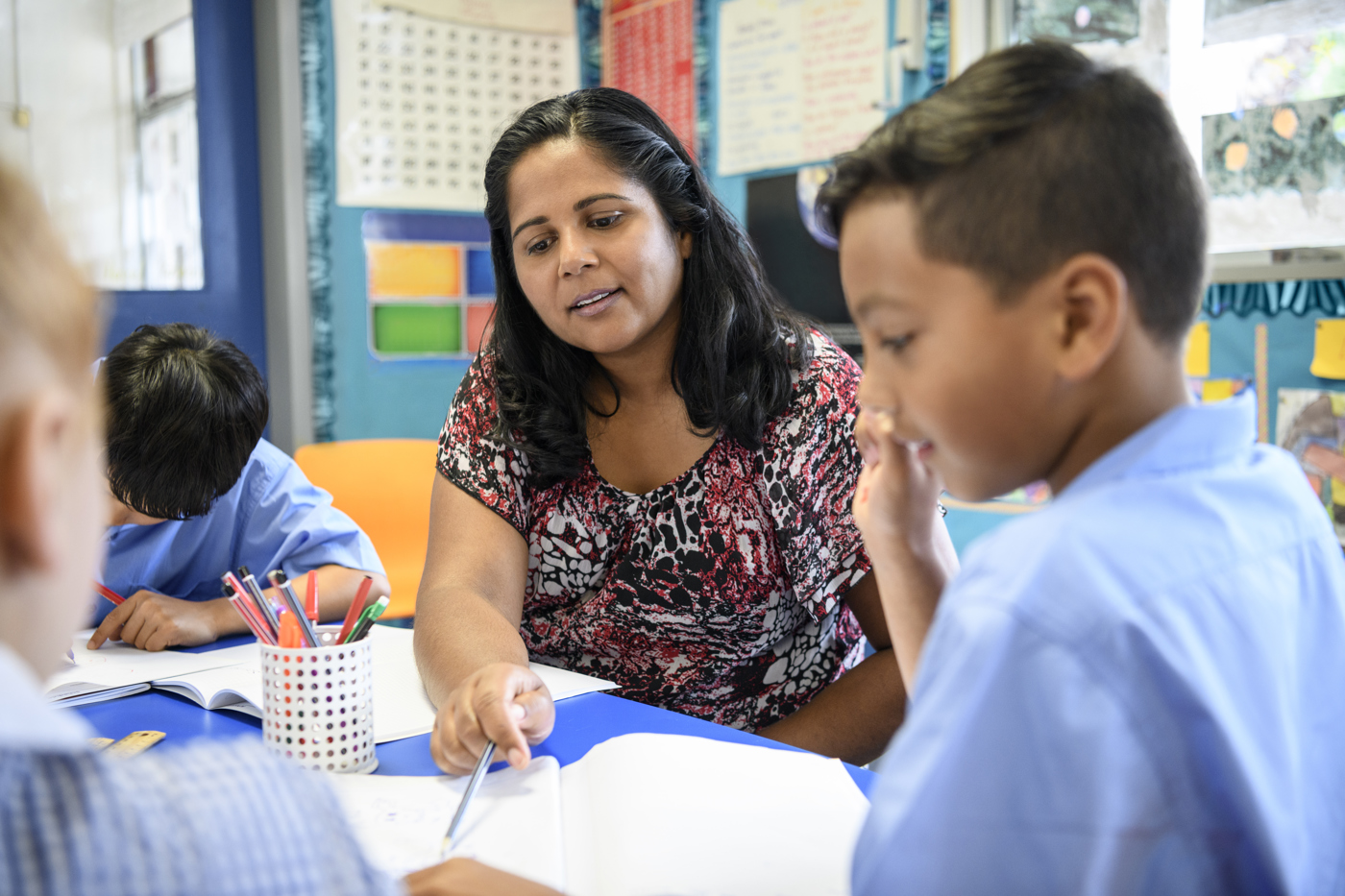 Female tutor with two primary school aged students, one male, one female