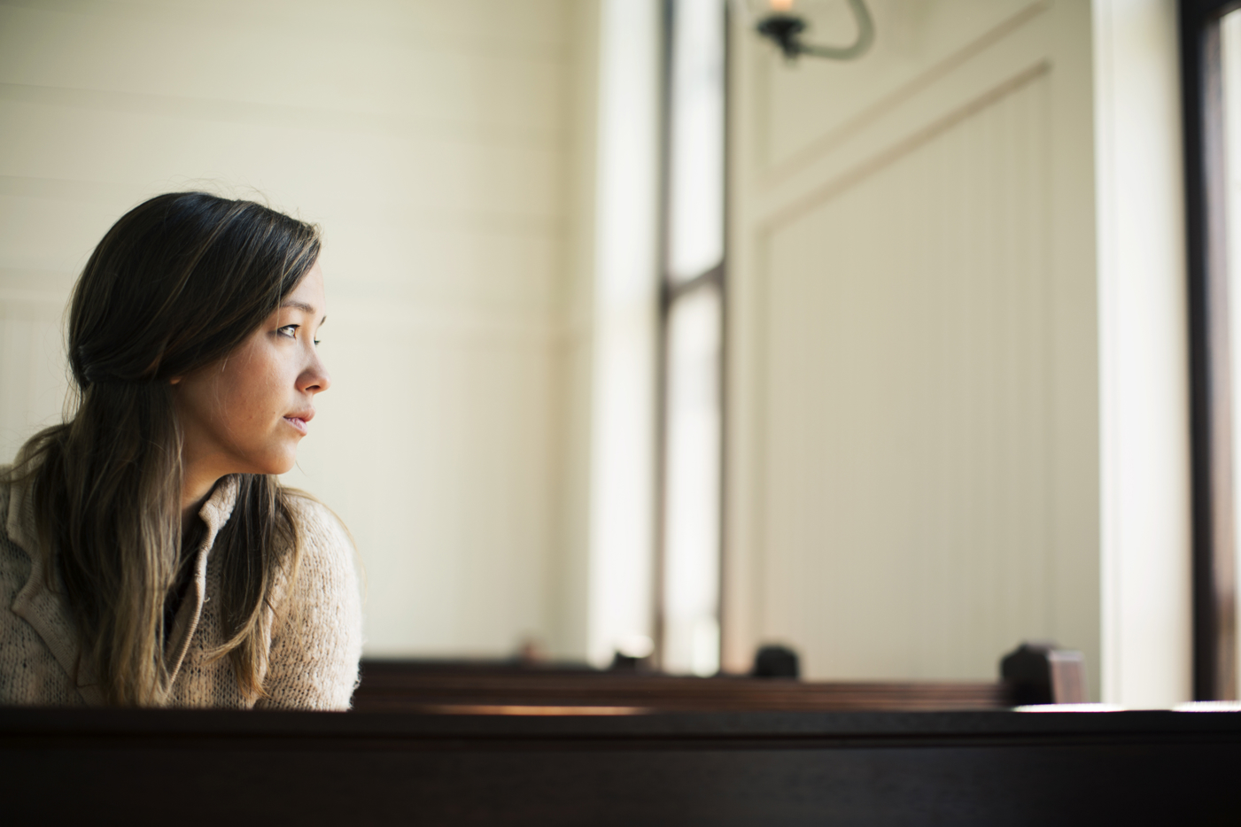 Woman sitting in church looking out of window