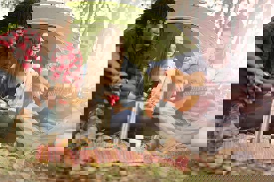 Three young people singing in front of a tent