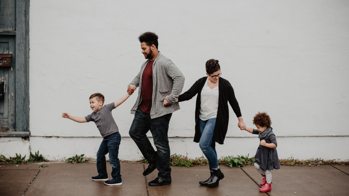 a family of two children, mum and dad out for a walk. 